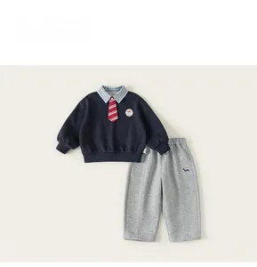 Détail du sweat-shirt garçon à col écossais et broderie de chien sur le pantalon gris