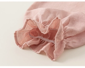 Detail view of the pink cotton linen cuff with elastic ruffle and natural texture