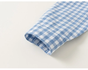 Close-up of blue and white gingham cotton shirt cuff showing fine stitching detail