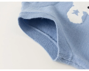Detail of baby boy sky blue knit vest showing fine texture and white star jacquard pattern