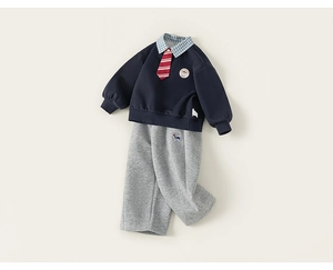 Détail d'une tenue d'écolier britannique pour garçon avec sweat bleu et jogging gris