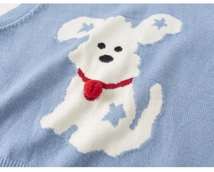 Detail of light blue knit vest with white cartoon dog pattern and red plush pompom