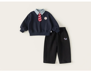 Détail de l'ensemble preppy pour garçon avec sweat marine et pantalon noir sport