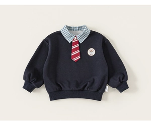Détail d'un sweat bleu marine pour garçon avec col à carreaux, cravate et écusson ours