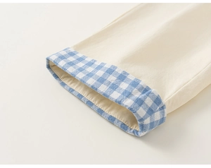 Detailed close-up of beige twill cotton sleeve cuff with blue gingham lining accent