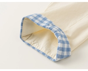 Detailed close-up of boy's beige twill cotton pants with blue gingham cuff lining
