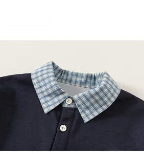 Détail du col polo bleu marine avec coutures à carreaux et broderie Stay Child