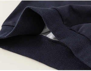 Gros plan des poignets côtelés bleu marine du sweat pour enfants avec coutures de qualité