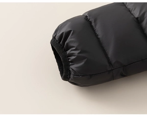 Détail des poignets élastiques sur une doudoune noire d'hiver avec tissu matelassé