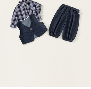 Détail d'un ensemble trois pièces enfant avec chemise à carreaux, gilet et jean