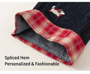 Dettaglio dei jeans con risvolti a quadri rossi a contrasto e ricamo a cucciolo