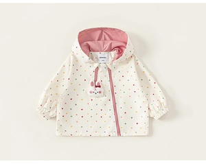 Close-up of kids cream hooded jacket with colorful polka dots and cute bunny zipper charm