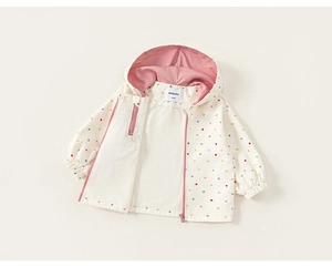 Detail of baby hooded jacket with polka dot print, pink lining, and elastic cuffs