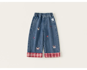 Dettaglio di jeans per bambini con vita elastica, ricami e risvolto a quadri rossi