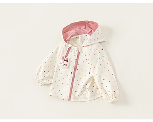 Detail of baby girl hooded jacket featuring colorful polka dots and cute bunny patch