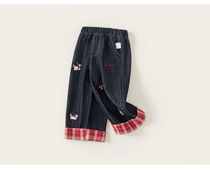 Detail of girl's denim pants with colorful puppy embroidery and red checkered cuffs