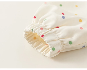 Detail of elastic ruffled cuffs on a colorful polka dot hooded jacket for girls