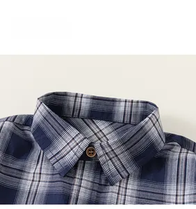 Gros plan du col de chemise à carreaux bleu et marron avec bouton en bois et texture