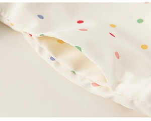 Detail of a kids polka dot windbreaker featuring colorful prints and side pocket stitching
