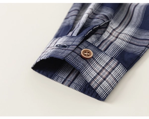 Détail du poignet de chemise à carreaux bleu marine avec bouton et coutures précises