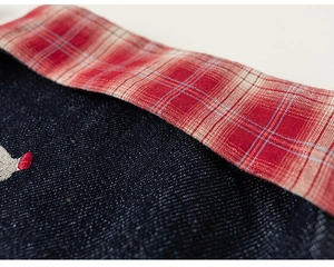 Dettaglio in denim blu con fodera a quadretti bianchi e rossi e ricamo fine