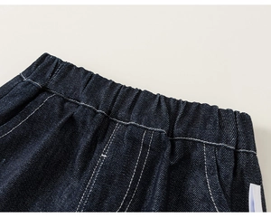 Detail of children's denim pants featuring elastic waistband and white contrast stitching