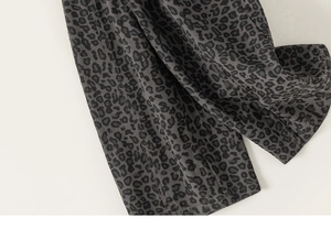 Detailaufnahme des dunkelgrauen Baumwollstoffs mit Leopardenmuster auf Kinderhosen