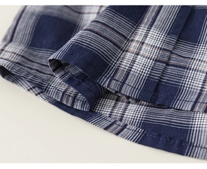 Gros plan de l'ourlet de la chemise à carreaux bleu marine avec double couture et texture