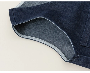 Gros plan sur les coutures du tissu denim bleu marine et détails de finition du vêtement