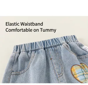Detailed view of kids denim pants featuring elastic waistband and heart-shaped checkered patch