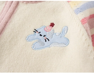 Detail van de gebreide textuur met schattig kattenborduurwerk op gestreept vestje