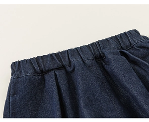 Détail d'un pantalon en denim bleu foncé avec taille élastique et texture sergée