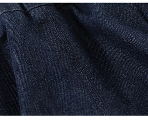 Gros plan du tissu denim bleu foncé avec coutures renforcées à une aiguille de haute qualité