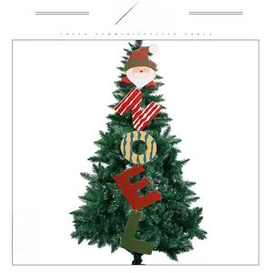 Close-up of wooden NOEL Christmas ornament with Santa Claus hanging on a green tree