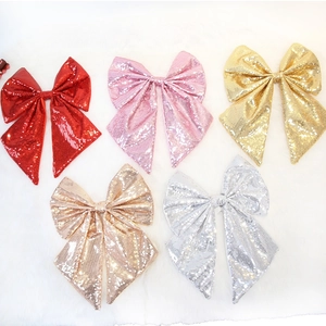 Fiocchi glitterati con paillettes in rosso e rosa su pelliccia per decorazioni festive