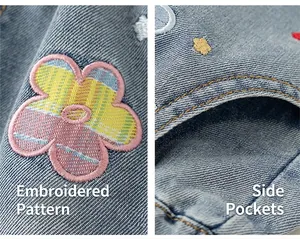 Detalle de pantalones vaqueros azules para niña con bordado floral y bolsillo lateral