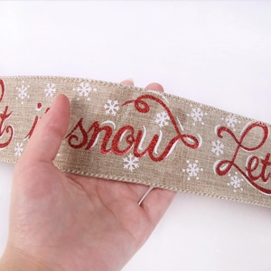 Macro detail of faux burlap Christmas ribbon with red Let it Snow sequins and snowflakes