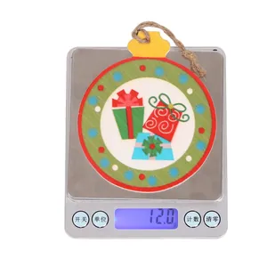 Close-up of a wooden Christmas tree ornament on a digital scale showing 12.0g weight