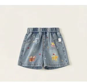 Detalle de pantalones cortos vaqueros azul claro con bordados florales y cintura elástica