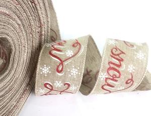Close-up of burlap Christmas ribbon roll with red Let it snow text and white snowflakes