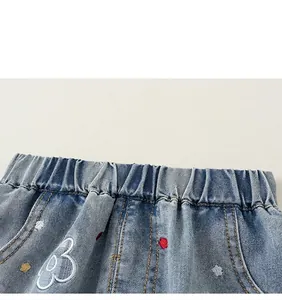 Detalle de la cintura elástica en vaqueros celestes para niña con bordado floral