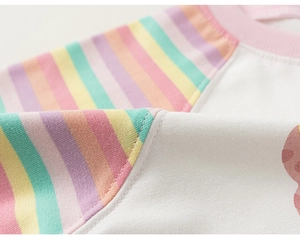 Detail van regenboog gebreide mouwen en zachte witte stof op een vest voor kinderen