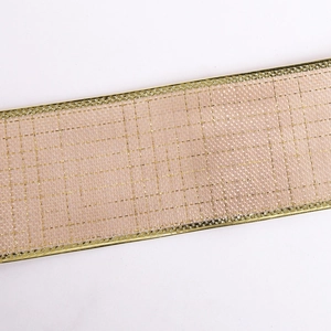 Macro view of champagne pink ribbon with gold wire checkered pattern and metallic edges