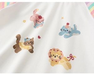 Detail van het witte gebreide vest met regenboogstrepen en schattige cartoon kattenprint