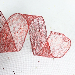 Detail of red hollow mesh Christmas ribbon with sparkling glitter for tree decoration