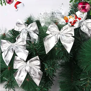 Silver metallic bow ornaments with micro-grid texture on green Christmas tree branches