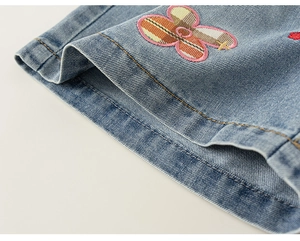 Primer plano de tela vaquera azul claro con bordado floral y diseño de cuadros