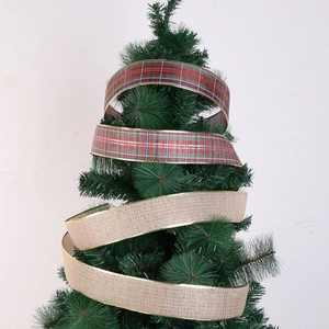 Detail of red plaid and beige linen Christmas ribbons spiraling around a green tree
