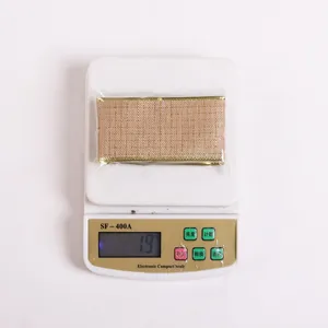 Detailed view of 19g khaki Christmas ribbon with gold mesh texture on a scale