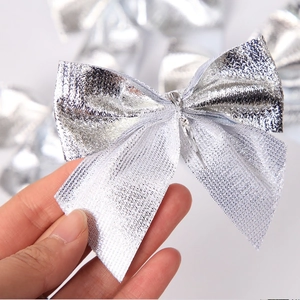 Close-up of silver Christmas bow ornament showing metallic texture and sheer mesh details
